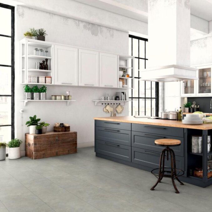 Raumfoto eines Laminats in einer Küche. Das Laminat hat eine graue Steinfliesenoptik und besonders breite Dielen.