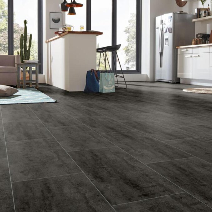 Raumfoto eines Laminats in einer Küche. Das Laminat hat eine schwarze Fliesenoptik mit hellgrauen Fugen.