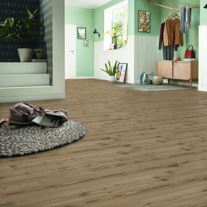 Raumfoto eines Laminats in der Optik von braunem Pinienholz mit starken Furchen und Rissen in einem großen Flur 