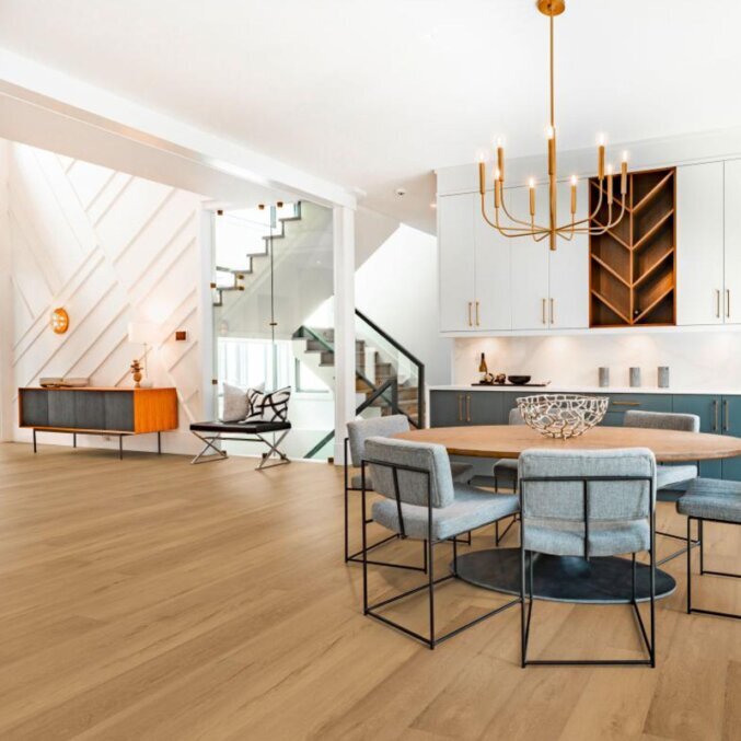 Raumfoto eines Laminats in einem Esszimmer. Das Laminat hat eine braune Eichenholzoptik mit dezenten Furchen und Rissen.