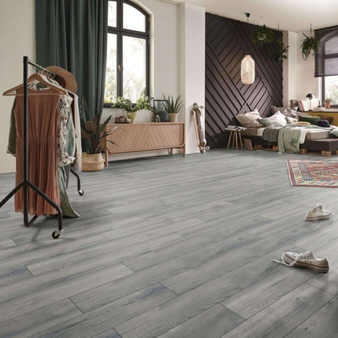 Raumfoto eines Laminats in eher dunkler und grauer Eichenholzoptik in einem großen Schlafzimmer mit leichten dunklen Maserungen