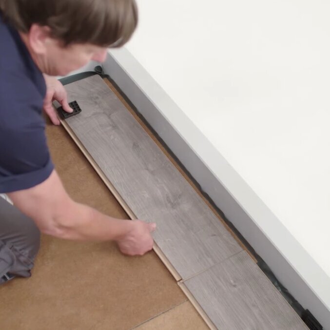 Aufnahme eines Mannes der Laminat verlegt