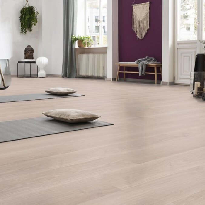 Raumfoto eines Laminats in cremeweißer Eichenholzoptik und feinen Maserungen in einem Raum mit Yogamatten