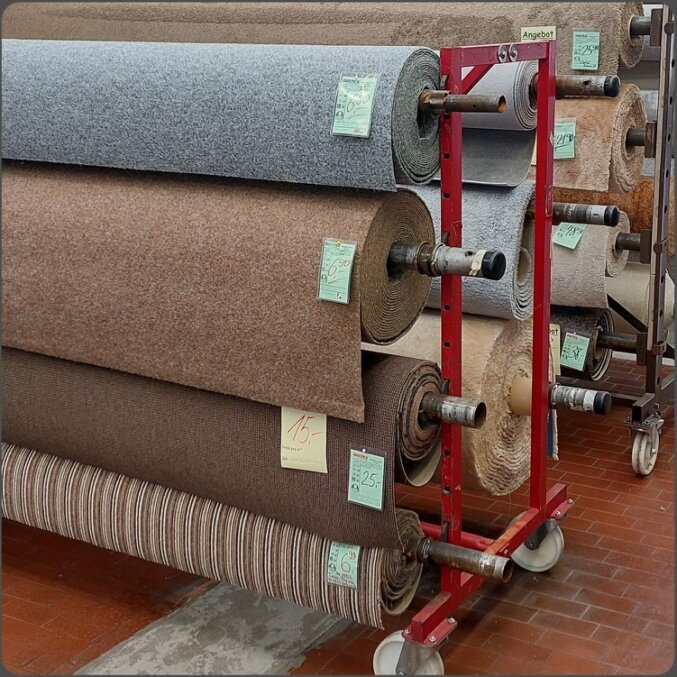 Bild der Laminat-Ausstellung von Baltex Bodenbeläge. Erkennbar sind diverse ausgestellte Böden mit Fläche zum ansehen des Bodens und Kartonagen der Böden unter den Flächen.