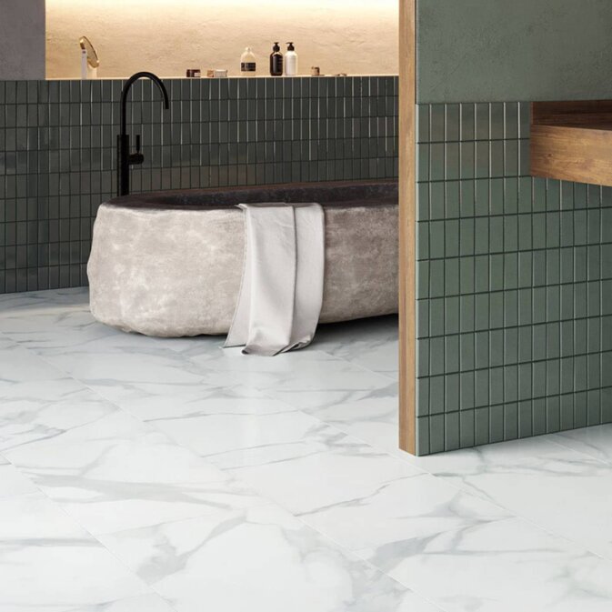 Klebe-Vinyl in Fliesenoptik in einem Badezimmer. Die Optik erinnert an weißen Marmor mit dunkelgrauen Elementen beziehungsweise Marmorierungen.<br />