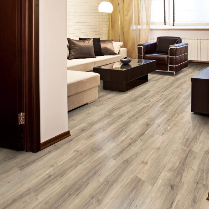 Klick Vinyl in Holzoptik in einem Wohnzimmer. Farblich ist der Boden in einer Mischung aus Grau und Braun gehalten mit vielen dunkleren Elementen in Dunkelgrau