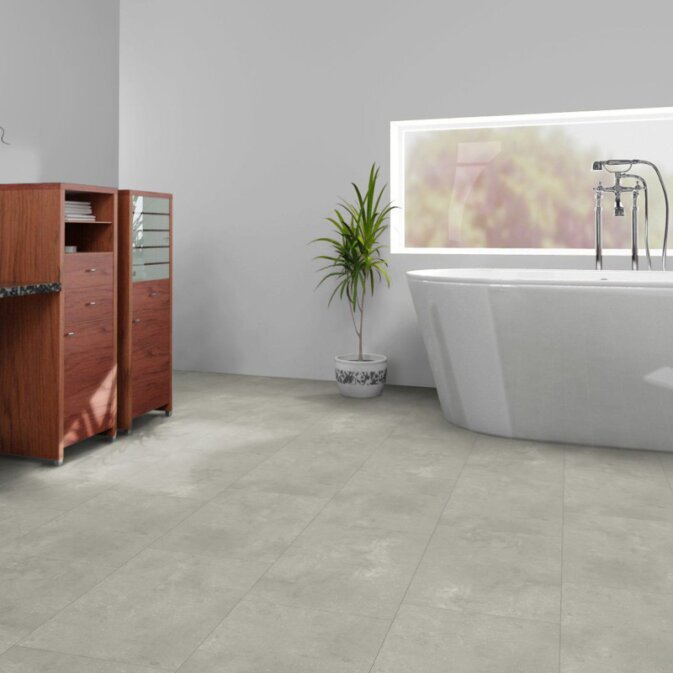 Klick Vinyl in Betonoptik in einem weißen Badezimmer. Die graue Betonoptik ist etwas aufgehellt und mit Beige vermischt, was den Eindruck von Beton vermischt mit Sand erzeugt.